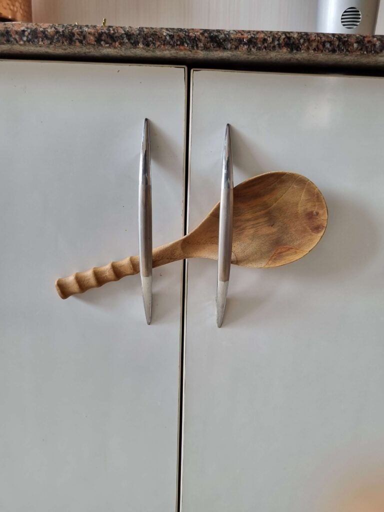 A wooden spoon holding cabinets shut