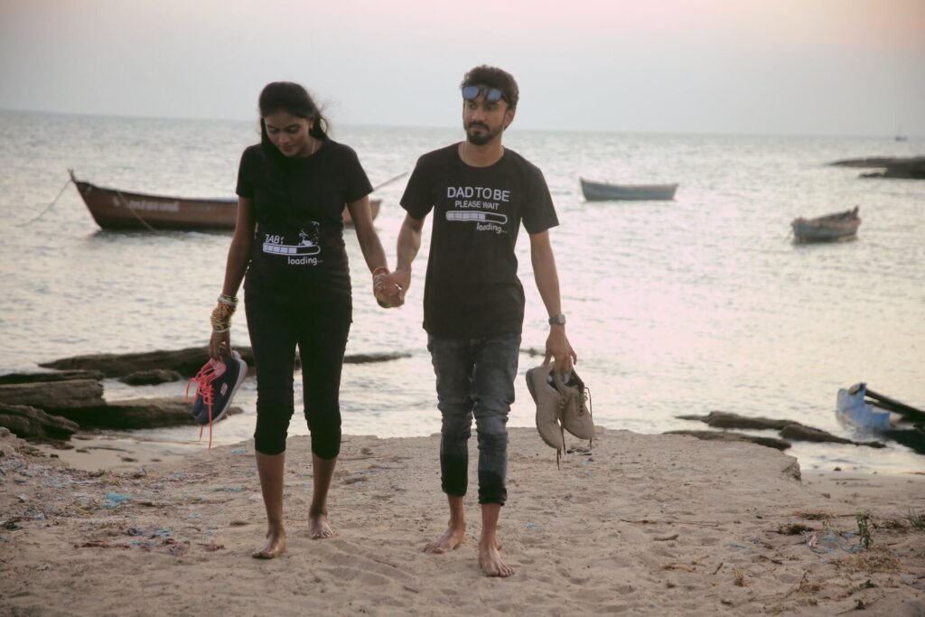 Expecting Indian couple walking at the beach