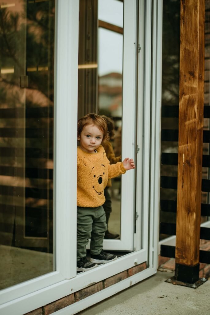 Infant standing on the ledge of a balcony