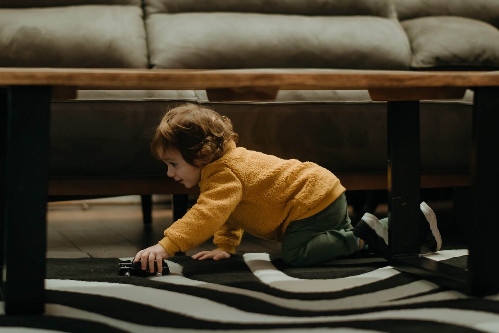 Child playing on the floor near a coffee table