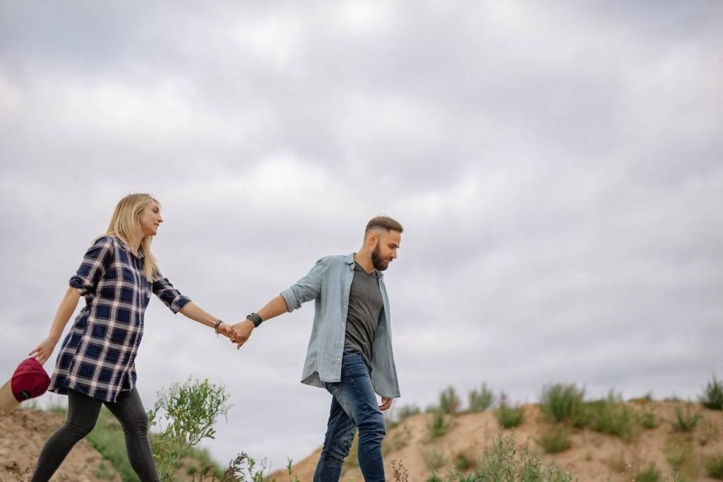 Pregnant woman walking on the beach with her partner