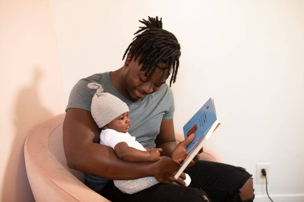 Dad bonding with infant by reading to him