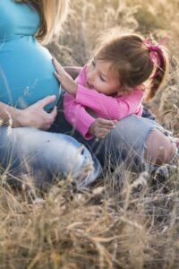 infant touching pregnant mother's belly